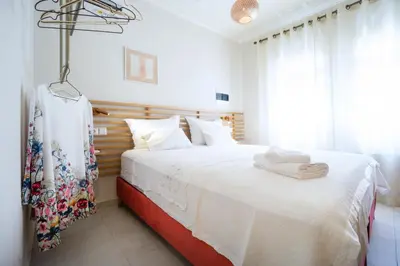 a bedroom with a large bed with white sheets at Kallinikou Residence - private parking on demand - in Chania Town