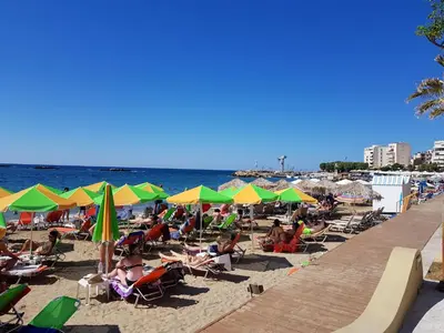 a crowded beach with people sitting in chairs and umbrellas at Palm Luxury Studios in Chania Town