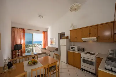 a kitchen with a dining table and a kitchen with a view at Rouladina Apartments in Stalos