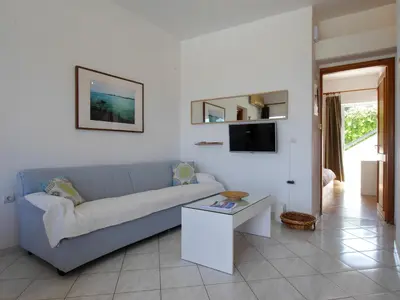 a living room with a blue couch and a table at Rouladina Apartments in Stalos