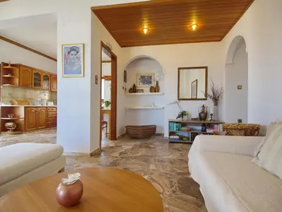 a living room with a white couch and a table at Rouladina Apartments in Stalos