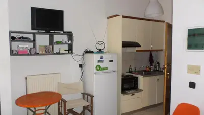 a kitchen with a small table and a refrigerator at Summer Holidays Studio in Chania Town