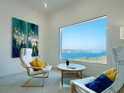 a living room with a large window and a table and chairs at Villa Nikos Megala Chorafia Crete in Áptera