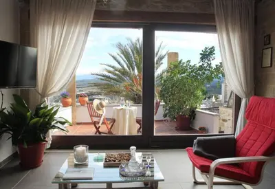 a living room with a large window looking out onto a patio at Charming villa in Chania with parking included in Kolymvari