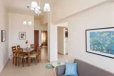 a living room and dining room with a dining table at Lily of Crete 2 - Sea & Beach front Apartment in Kato Galatas