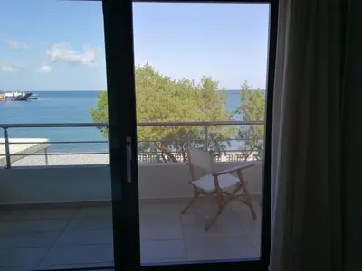 a room with a view of the ocean from a balcony at Amoutsa Seaside Villa in Kolymvari