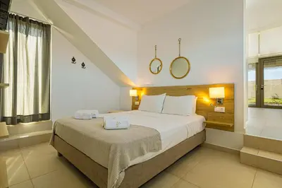 a bedroom with a large bed with two towels on it at Cocoon Luxury Villas in Maleme