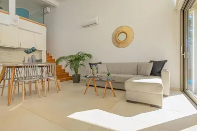 a living room with a couch and a table at Cocoon Luxury Villas in Maleme