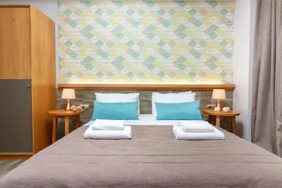 a bedroom with a large bed with blue pillows at Rigas City Apartment (BLUE) in Chania Town