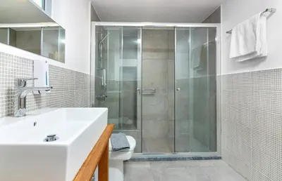 a bathroom with a shower and a sink and a toilet at Rigas City Apartment (BLUE) in Chania Town