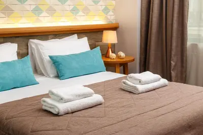 a hotel room with two beds with towels on them at Rigas City Apartment (BLUE) in Chania Town