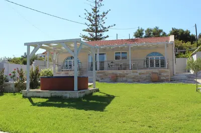 a house with a pergola in a yard at Villa Sea Dream Almyrida in Almirida