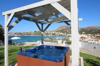 a hot tub under a pergola with a view of the ocean at Villa Sea Dream Almyrida in Almirida