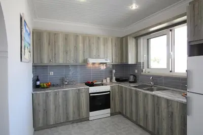 a kitchen with wooden cabinets and a sink at Villa Sea Dream Almyrida in Almirida