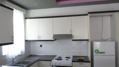 a kitchen with white cabinets and a stove top oven at Top Holidays Apartments in Chania Town