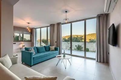 a living room with a blue couch and a large window at Villa Vasiliki in Stalos