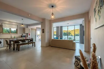 a kitchen and living room with a table and a couch at Villa Vasiliki in Stalos