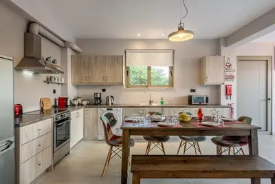 a kitchen with a wooden table and chairs at Villa Vasiliki in Stalos