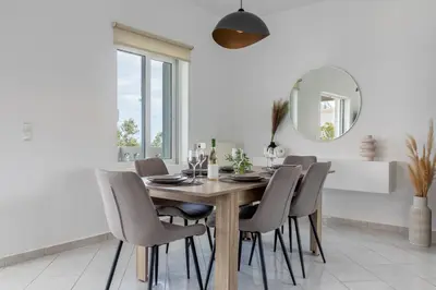 a dining room with a wooden table and chairs at Villa Kelaidis in Megála Khoráfia