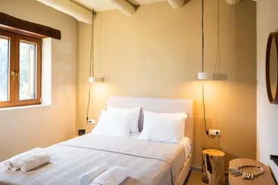 a bedroom with a bed with white pillows and a window at Prinus Country Retreat Apokoronas, heated pool, 13km from the sea in Embrósneros