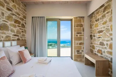 a bedroom with a bed with a view of the ocean at Blue Horizon Luxury Villas in Falasarna