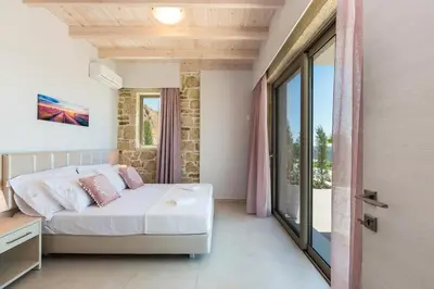 a bedroom with a bed and a large window at Blue Horizon Luxury Villas in Falasarna