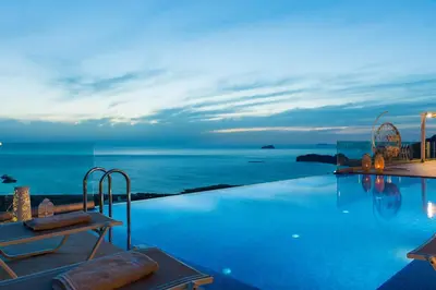 a pool with a view of the ocean at night at Blue Horizon Luxury Villas in Falasarna
