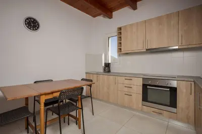 a kitchen with wooden cabinets and a wooden table and chairs at Villa Konstantinos Hilltop Vineyard Escape in Chania Town