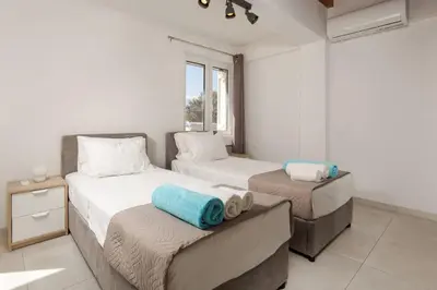 a bedroom with two beds and a window at Villa Konstantinos Hilltop Vineyard Escape in Chania Town
