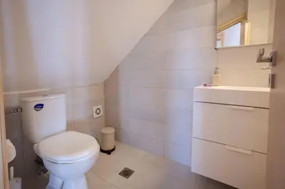 a white bathroom with a toilet and a sink at Villa Konstantinos Hilltop Vineyard Escape in Chania Town