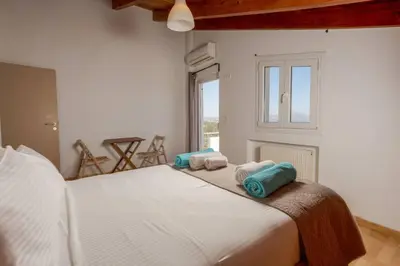 a bedroom with a large white bed with towels on it at Villa Konstantinos Hilltop Vineyard Escape in Chania Town
