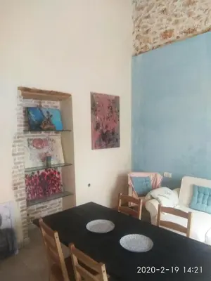 a dining room with a table and a couch at Spartis House 30m from the beach in Chania Town
