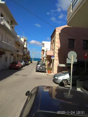 a street with cars parked on the side of the road at Spartis House 30m from the beach in Chania Town
