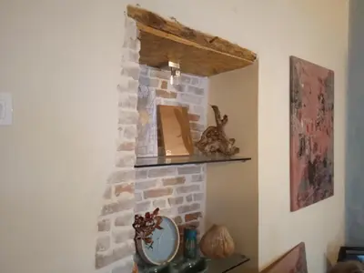 a room with a stone fireplace with a mirror at Spartis House 30m from the beach in Chania Town