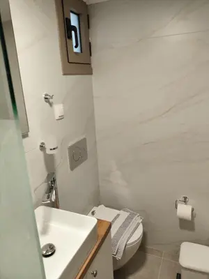 a white bathroom with a toilet and a sink at Protopapas in Palaiochóra