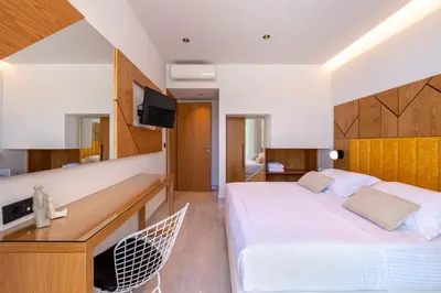 a bedroom with a bed and a desk with a television at Villa Lydia I Superb views, two pools, next to the city in Kissamos