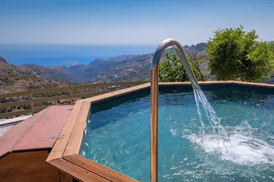 a swimming pool with a water fountain at Best View Mountain Villa in Teménia