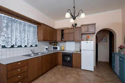 a kitchen with wooden cabinets and a white refrigerator at Best View Mountain Villa in Teménia