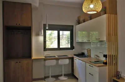 a kitchen with a counter and two stools in it at Antigonis Garden House in Chania Town