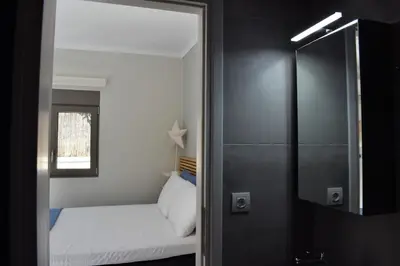 a small bedroom with a bed and a mirror at Antigonis Garden House in Chania Town