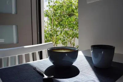 a cup of coffee sitting on a table with a spoon at Antigonis Garden House in Chania Town