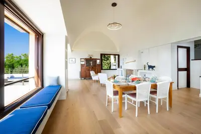 a dining room with a table and chairs and a large window at Kassiopeia Villa in Chania Town