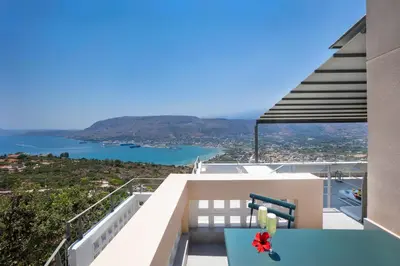 a balcony with a table and a view of the water at Kassiopeia Villa in Chania Town