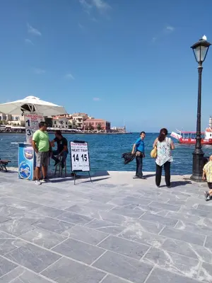 a group of people standing on a pier near the water at Marinos Suites in Chania Town