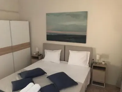 a bedroom with a white bed with blue pillows at Marinos Suites in Chania Town