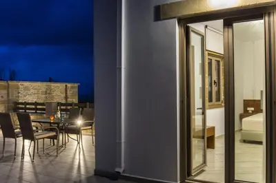 a room with a balcony with a table and chairs at Agarathos Deluxe Homes In the Heart of Kaliviani Near Balos in Kissamos