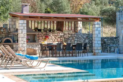 a patio with a table and chairs next to a swimming pool at Cretan Lux Villa Heated Pool in Gavalochori