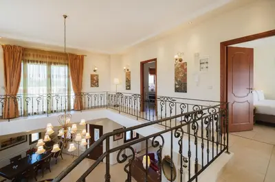 a living room with a staircase and a dining room at Ar & Al Luxury Villa in Galatás