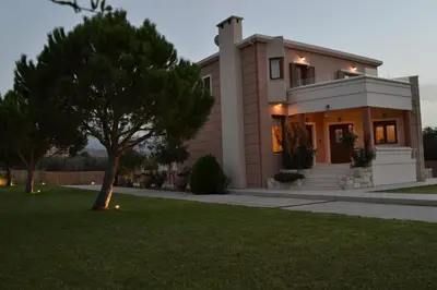 a house with a tree in front of it at Ar & Al Luxury Villa in Galatás