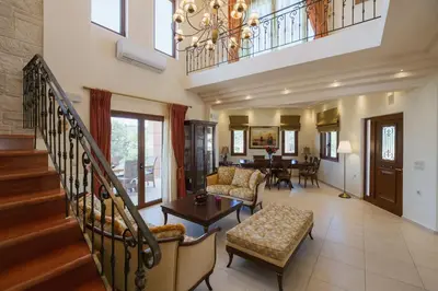 a living room with a staircase and a dining room at Ar & Al Luxury Villa in Galatás